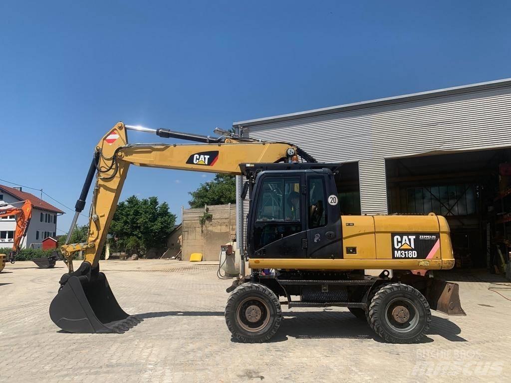 CAT M 318 D حفارات بعجل