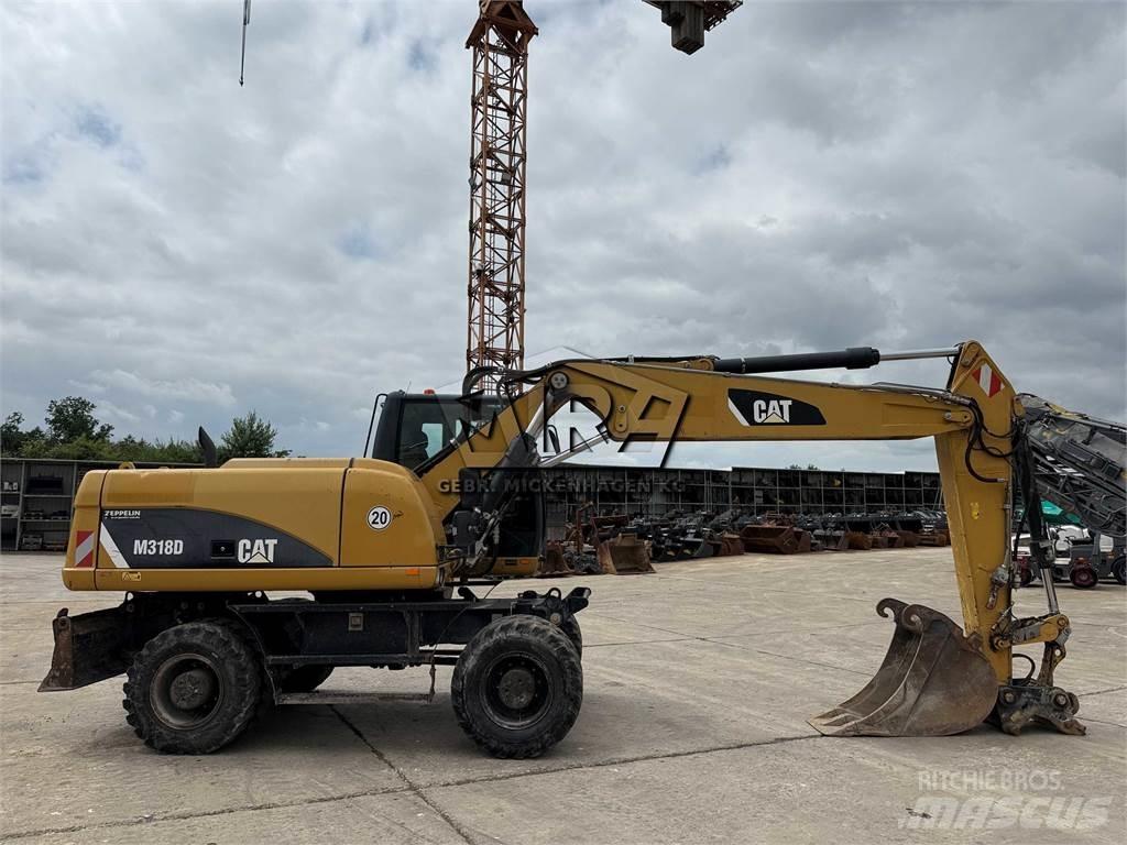 CAT M 318 D حفارات بعجل
